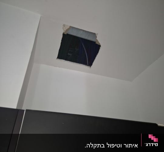 תקרה עם חור וחוטי חשמל גלויים